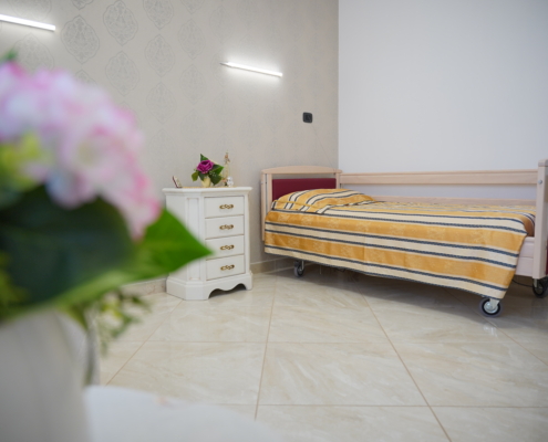 dettaglio dorata intarsiata comodino con fiori e lettino ortopedico regolabile