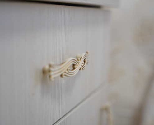 dettaglio maniglia dorata intarsiata comodino